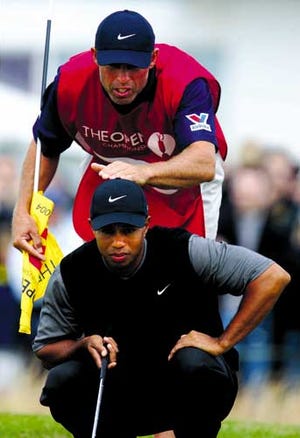 Tiger Woods and his caddie Steve Williams line up a putt on the 2nd green at Royal Troon golf course. Ten players are within five shots of the lead, and five of them were major champions.