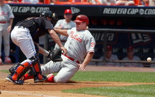 Philadelphia's Jim Thome beats the throw to home plate as New York catcher Jason Phillips attempts to tag him out Saturday at Shea Stadium.