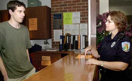 Chris Wells, a Murphree Commons desk assistant, talks July 17 with Holly Thomas, a University Police Department officer.