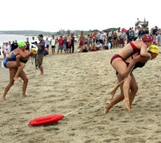Salisbury lifeguard Jackie Donnally carries "victim" Michelle Filteau to a first-place finish in the Cape Cod Lifesaving Competition yesterday at Hardings Beach in Chatham. They are followed by Nauset lifeguard Katie McCully and Caitlin Gillen.