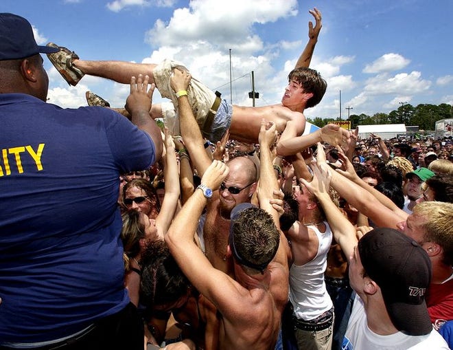 Fans pass a crowd surfer toward security during the 2002 Vans Warped Tour in Jacksonville.