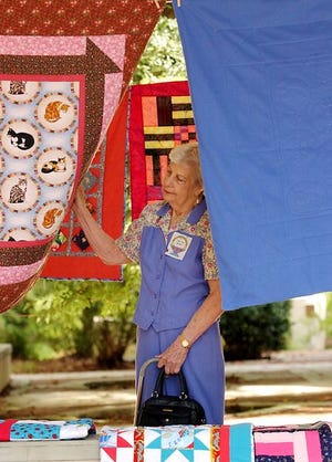 Cora Lee Brewer of Gainesville looks at the quilts to be donated. Brewer is a member of the Quilters of Alachua County Day Guild. "I'm a quilter,'' said Brewer. "We always check out everything."