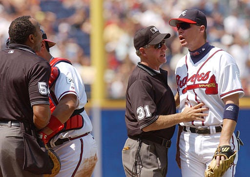 Atlanta's Chipper Jones and home plate umpire C.B. Bucknor, left, are held back Saturday by umpire Mike Reilly and catcher Eddie Perez as they argue during the Braves' 9-7 win over St. Louis.
