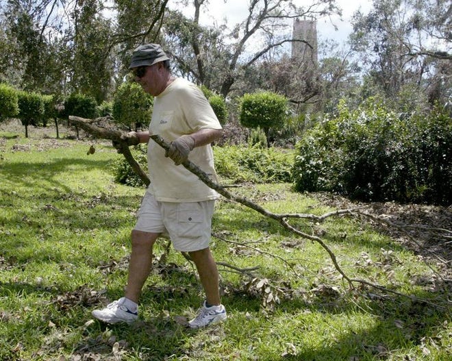 Bob Stucker, a volunteer from Miami, helps haul away tree limbs at Historic Bok Sanctuary in Lake Wales on Sunday. The sanctuary's gardens took the worst Hurricane Charley could dish out, but the 205-foot carillon tower survived unscathed.
