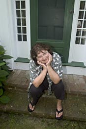 Author Alice Hoffman poses on the front step of her antique Wellfleet home, the inspiration for her new book, "Blackbird House."