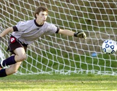 Nantucket goalie Rob Lucchini dives to stop a shot from in close during yesterday's 1-0 win at Cape Cod Academy.