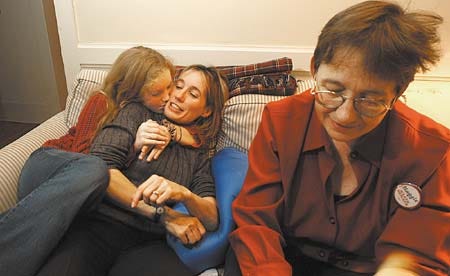 Maggie Wood Hassan gets a hug from her 11-year-old daugher, Margie, Tuesday evening after they and Hassan's sister, Franny Wood, right, learned she won Newmarket in the District 24 race for State Senate. Hassan lost that town in her unsuccessful bid for the same seat two years ago.