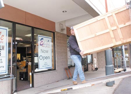 Gary Kelly, of Ray the Mover moving company, helps carry furniture and other items into Eagle Photo's new home at 728 Islington Street in Plaza 800 on Friday. Eagle Photo moved from its building on Market Square.