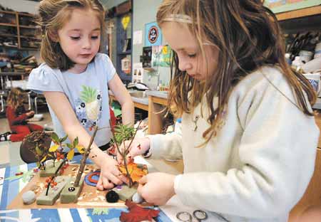 First-graders Madison Carter, left and Klera Moyer build their own garden during a class at Kensington Elementary School with artist-in-residence Laura Campbell, who is a landscape designer from Peterborough.