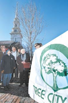 Mary Reynolds, urban forester with the N.H. Division of Forests and Lands gives a Tree City USA flag to Portsmouth Mayor Evelyn Sirrell and members of the Blue Ribbon Committee on Trees and Public Greenery in Market Square on Wednesday. Portsmouth is one of 19 Tree Cities in the state.Rich Beauchesne