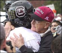 South Carolina coach Lou Holtz hugs Andrea Gause as he takes the field with his team against in-state rival Clemson, Saturday, Nov. 20, 2004, at Memorial Stadium in Clemson, S.C. Holtz has announced the he will step down as coach at South Carolina.