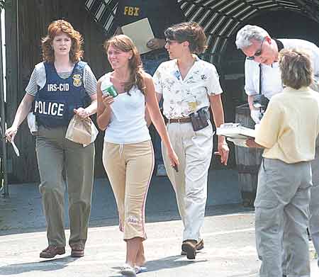 Federal agents escort a woman from the Danish Health Club in Kittery, Maine, during a raid on June 9.