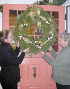 Jo Ann Eves and Anne Humphrey hang a festive holiday wreath on the front door of Jo Ann and Art Eves' York Harbor home in anticipation of this weekend's York Harbor Holiday Open-Home Stroll. Humphrey of York Corner True Value made and donated the wreath above as well as several others for the special event to benefit the York Public Library.