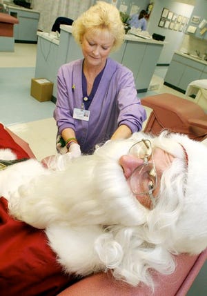 Santa Claus, who moonlights as Allan Richards, gives blood at the Blood Banks of Mid Florida donation center Tuesday in Winter Haven.