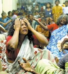 People displaced by the tsunami mourn their losses as they sit inside a relief camp at a temple in Varichikudi, about 125 miles south of Madras, India, Monday. AP photo