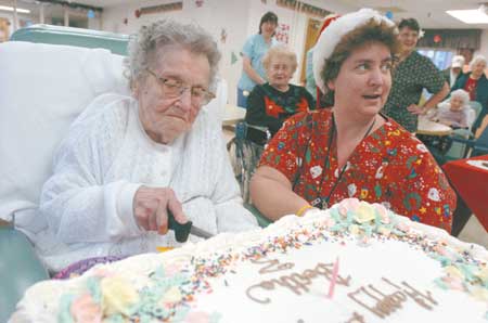 Bertha Cheney celebrates her 110th birthday with family and friends at the Rockingham County Nursing Home. Marilyn Schreiber, head nurse for Cheney's floor, helps Cheney cut her birthday cake.