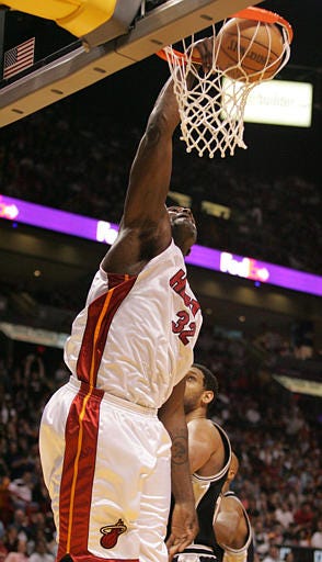 Shaquille O'Neal (32) dunks the ball on Tim Duncan during the second quarter Sunday in Miami.