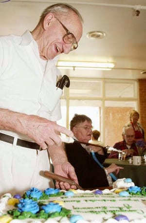 John Summey, 78, is honored Friday for his 10 years of service at Beystone Health and Rehabilitation in Fletcher. Here, he cuts his cake as the residents enjoy the party.