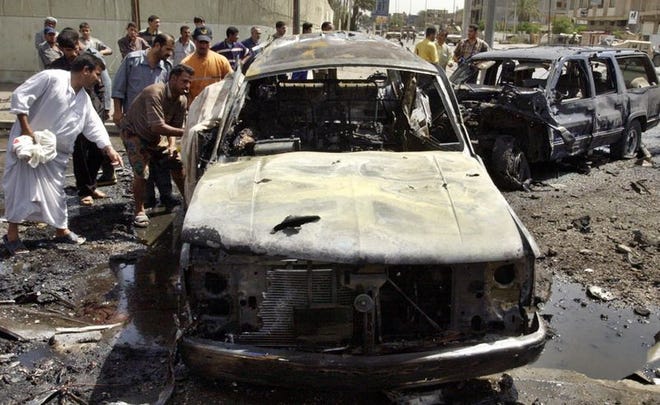 Iraqi men rush to the scene after a car bomb exploded outside a building holding a meeting of senior Sunni leaders from the Council on National Dialogue in Baghdad, Iraq, on Saturday.