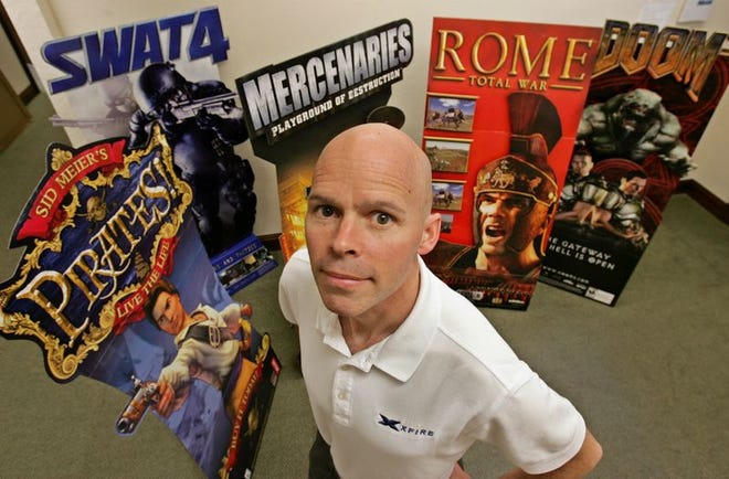 Xfire CEO Mike Cassidy stands in the lobby of his headquarters in Menlo Park, Calif. Xfire makes a very popular instant-messaging program for gamers. In the background are games that can use Xfire.