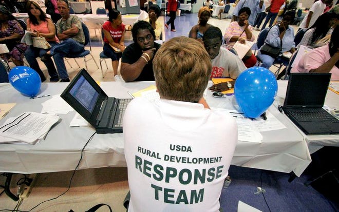 Residents meet with members of the U.S. Department of Agriculture to review applications for loans and grant money at The Lakeland Center on Saturday.