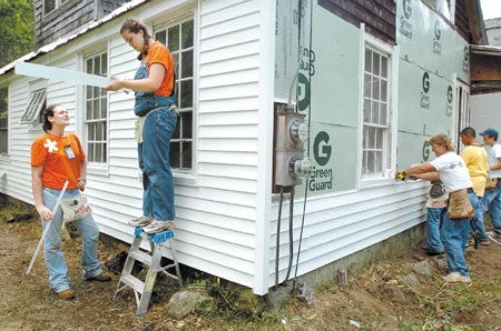 Teens from around the country are staying at Raymond High School while they help seacoast residents with major home improvements. Members of "World Changers", from left Ashton Gilpin, 16, Valerie Gardner, 15, and leader Robin Hills, at right, attach vinyl siding to the home of Nancy Bateman.