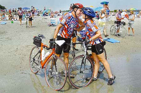 Greg Mongold, of Bloomington, Ind., kisses his wife at the shoreline of Wallis Sands Beach in Rye on Monday after traveling some 3,622 miles in 50 days as part of the America By Bicycle tour.