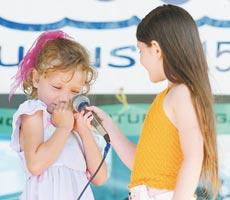 Lily Miller, left, loses her nerve as she was about to sing ?Twinkle, Twinkle, Little Star? during the talent show at the Children?s Festival at Hampton Beach. Her friend, Dominique Courchaine, convinced her to try, and Miller sang the entire song to rousing applause from the audience.