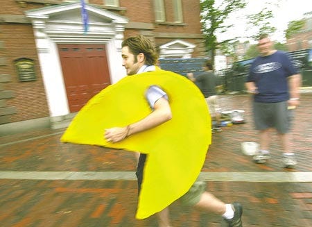 John Herman, as Pacman of the classic video game, runs off to hide from four ghost characters as other members of the local comedy group Stranger Then Fiction update the game's map behind him. The group, using two-way radios to track character's movements, truned downtown Portsmouth into a virtual reality version of the game.
