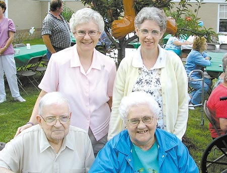 Sister Louise Auclair and Sister Theresa Auclair, standing, and Alphonse and Alice Auclair, seated, pose for a family photo during a barbecue and 60th anniversary celebration for New Hampshire Catholic Charities at the Saint Ann Healthcare Center and Bishop Gendron Apartments.