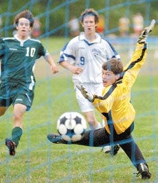 Winnacunnet High School?s Kevin Gnecco (9) watches his kick sail past Dover goalkeeper Greg Gilmore for the Warriors? third goal in their 3-0 win over the Green Wave on Monday.