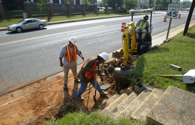From left, DRM Utilities employees Gilberto Cano, Alejandro Cano and Scott Morrison prepare the foundation for new sidewalks along Stillman Boulevard on Wednesday. The beautification project will require drivers and workers to coexist on the Tuscaloosa roadway for the next four moths.
