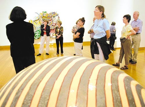 A group of visitors listens to an art discussion lead by Brandi Breslin, Education Coordinator for the Harn, in the new Mary Ann Harn Cofin Pavilion, near "Dango," a sculpture by artist Jun Kaneko, Saturday, October 22, 2005. Saturday marked the opening of the new pavilion, which houses "American Matrix," a collection of contemporary American art.