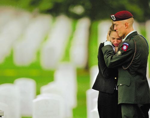 Nicole Hitzges, stepsister of Army Spc. Chad Keith, is comforted by a serviceman as they attend funeral services for Sgt. Keith in this Aug. 1, 2003, photo at Arlington National Cemetery.