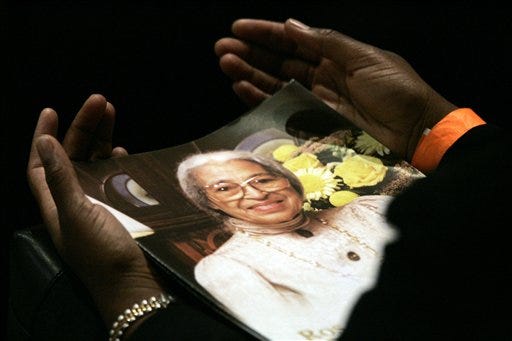 A mourner at the funeral for civil rights pioneer Rosa Parks holds the funeral program Wednesday in Detroit.