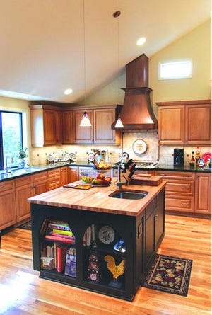 The Livaich's remodeled kitchen has butcheer block top on island and copper hood over stove.
