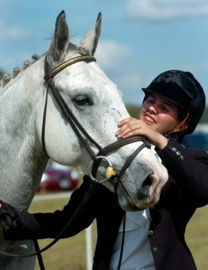 Ammanda Allain, above, pets Ford, an Irish sport horse, after the dressage event of the Ocala horse Trials on Saturday.