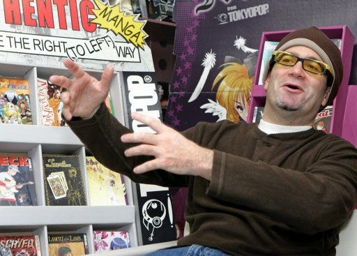 Above, Stuart Levy, chief executive of TOKYOPOP Inc., sits beside a rack of "manga" comics in Tokyo, Oct. 20. In January, the Sunday funnies of several major U.S. newspapers will add manga comic strips. Below, the cover page of “Van Von Hunter,” one of two manga works that will appear in papers.