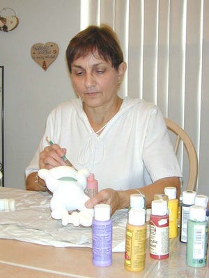 Marlene Adkins loves working on ceramics. She is busy painting two figurines, one for each of her grandchildren in Texas.