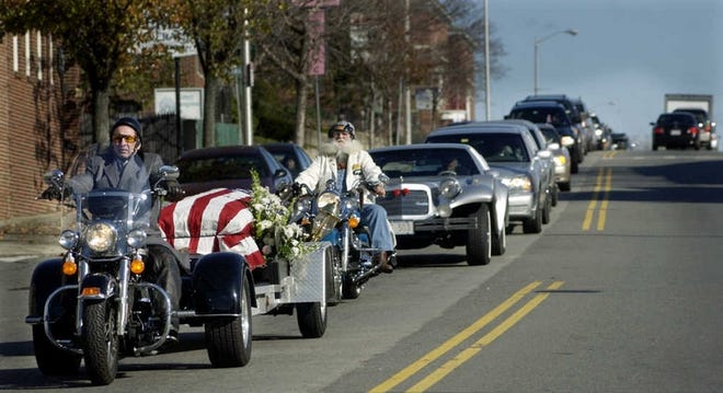 LAST RIDE: The casket of Bernard A. Roy, a motorcycle enthusiast, is led down Main Street, Worcester, by a three-wheel motorcycle toward Notre Dame Cemetery on Webster Street yesterday. Mr. Roy, 63, of Paxton, died Sunday. He was director of Alfred Roy & Sons Funeral Home in Worcester.