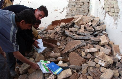 Faithful recover religious books from inside one of two mosques attacked in Khanaqin, Iraq, on Friday.