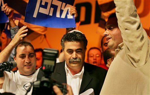 The new leader of Israel's Labor Party Amir Peretz is surrounded by supporters at a Labor Party convention in Tel Aviv, Israel, on Sunday. The Labor Party voted to pull out of Prime Minister Ariel Sharon's government.