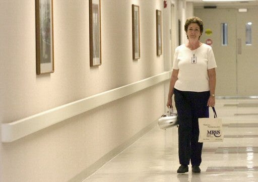 Nurse Vicki Stapp carries a "compassion bag" with prayer books and calming CDs on Monday to be shared with patients in their last hours before death at Munroe Regional Medical Center. Stapp is a volunteer with No One Dies Alone, a program that provides a companion to dying patients who would otherwise be alone.