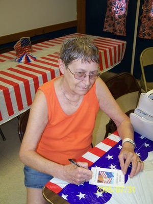 Rita Zastrow writes a greeting to American troops on a 'You are My Hero' card at an AmVets Post 19 Patriotic Sunday.