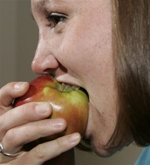 Jacqueline Mariash, 25, takes a bite out of an apple during an interview with her nutritionist in Denver.