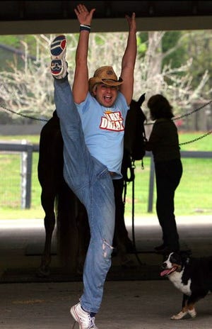 Glenn Packard, a professional choreographer, demonstrates a high kick in the barn area at his mom and dad's farm Dream Walkin Ranch.