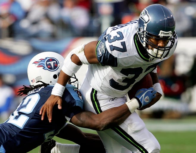 After scoring an NFL-record 28 touchdowns and rushing for a league-leading 1,880 yards, Seahawks running back Shaun Alexander, right, is given The Associated Press NFL Most Valuable Player award.