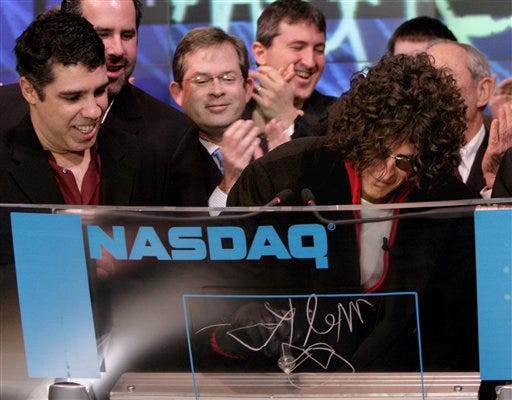 This photo released by NASDAQ shows radio personality Howard Stern signing in during the opening bell ceremony at the NASDAQ Market Site in New York last Tuesday. The Howard Stern Show premiers on Sirius satellite radio today. At left is Howard Stern Show cast member Boy Gary.