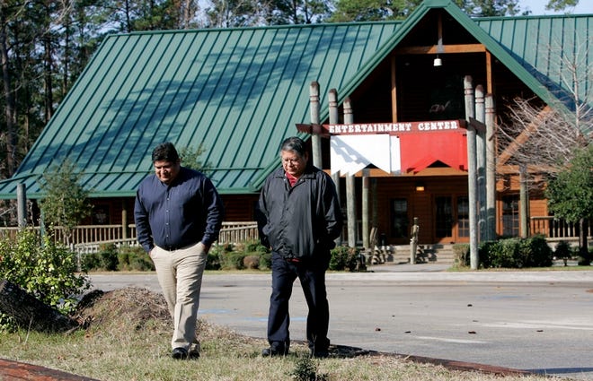 Carlos Bullock, left, and Herbert Johnson Sr., both members of the Alabama-Coushatta tribe of Texas tribal council, walk through a parking lot near the building where the tribe's casino was once located Tuesday in Livingston, Texas.
