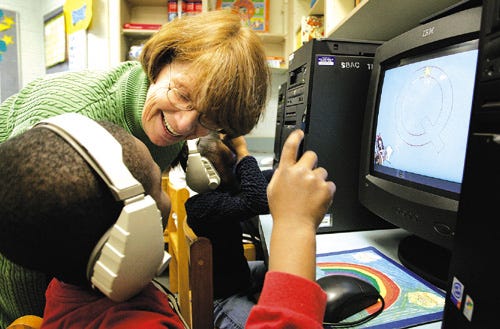 Kay Moore, a volunteer at Rawlings Elementary School, assists kindergartners with a computer reading program. Moore also does a host of other duties, including stuffing envelopes and assisting teachers. She's also president of the PTA.